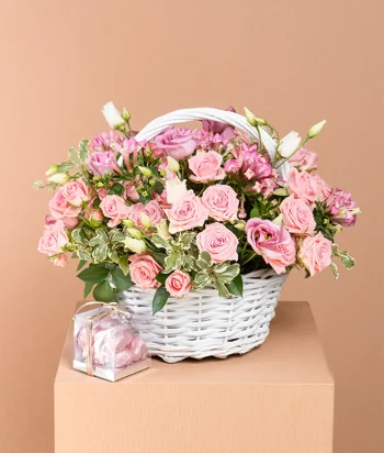 Pink rose and spray rose basket arrangement with chocolates